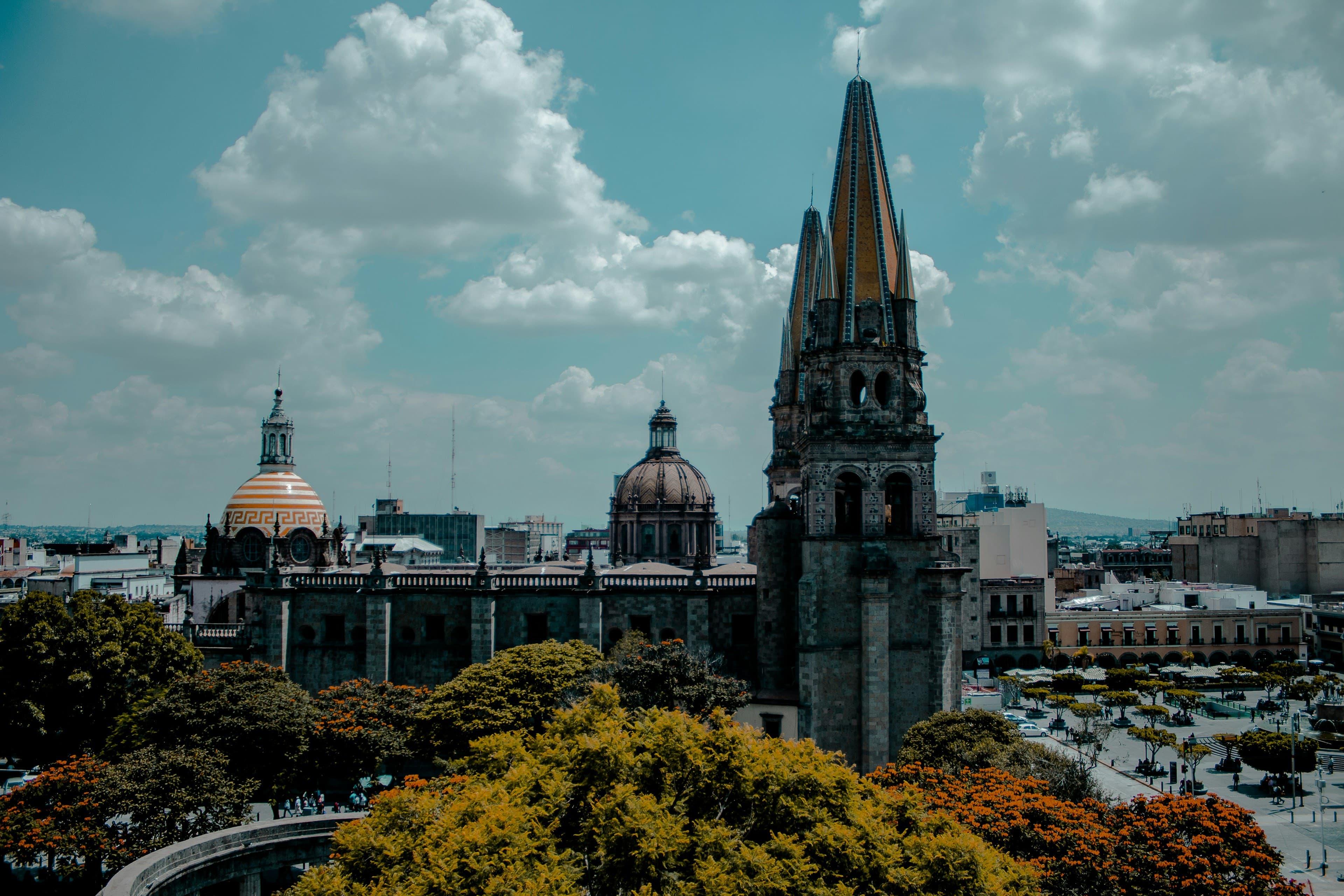 Guadalajara's Cathedral with its yellow neo-Gothic spires and tiled domes over the Plaza de Armas and historic centre.